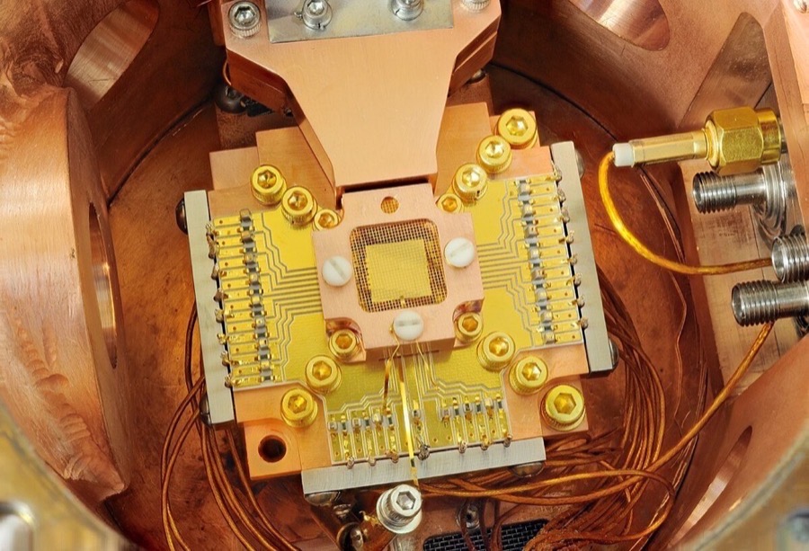 NIST trapped-ion quantum computing apparatus showing a chip with gold electrodes where ions are confined and manipulated with lasers